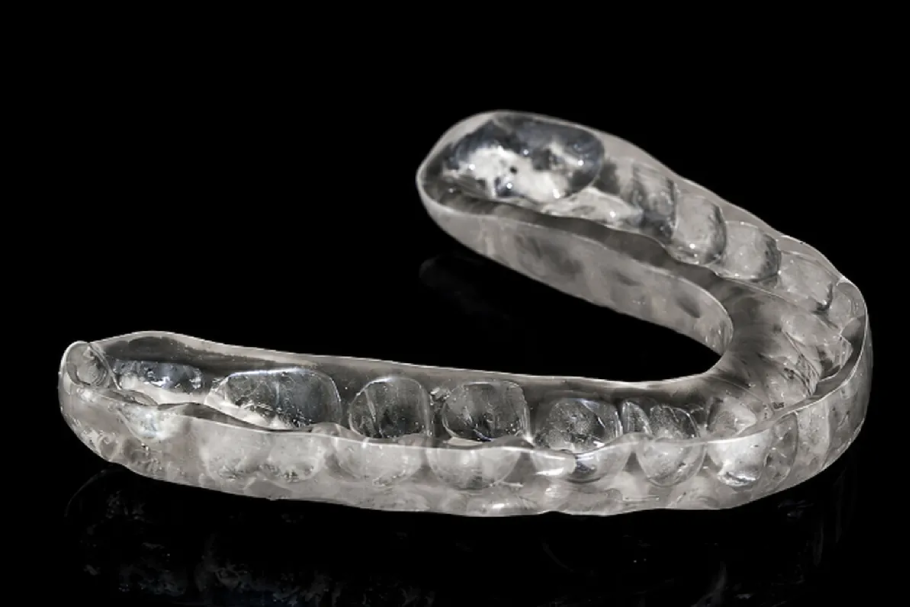 Clear dental mouthguard on black background.